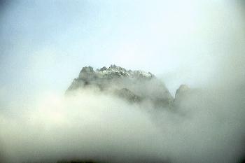 Berggipfel der die Sonne trotz Wolken findet